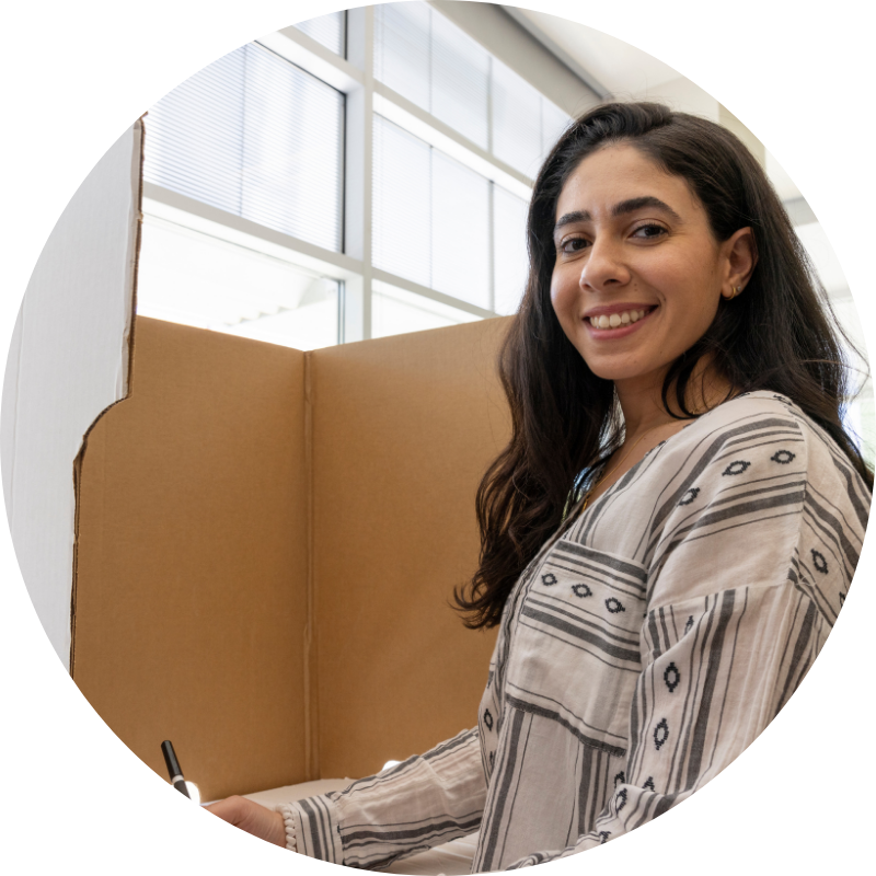 woman smiling at a voting booth