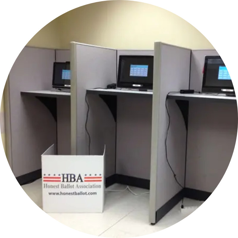 three computers set up in voting booths for an online election