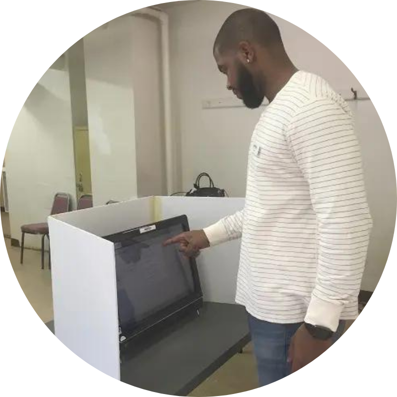 man wearing white shirt voting with a touchscreen machine